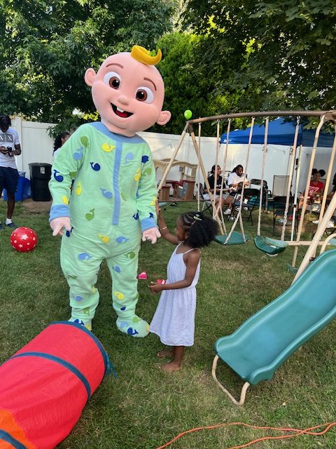 JJ from Cocomelon with a little girl next to a slide and swing set | Rent Party Characters
