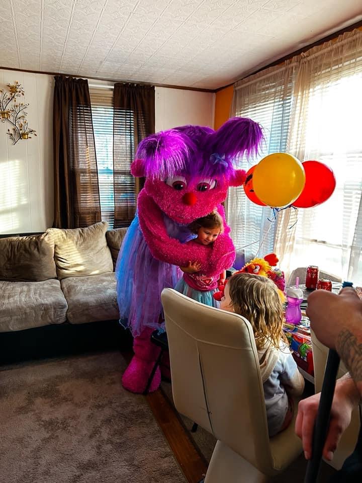 Abby Cadabby hugging a child next to balloons | Rent Party Characters