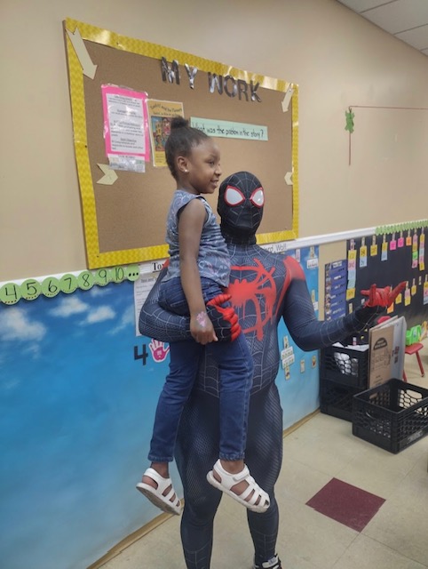 Miles Morales holding a girl in a classroom | Rent Party Characters