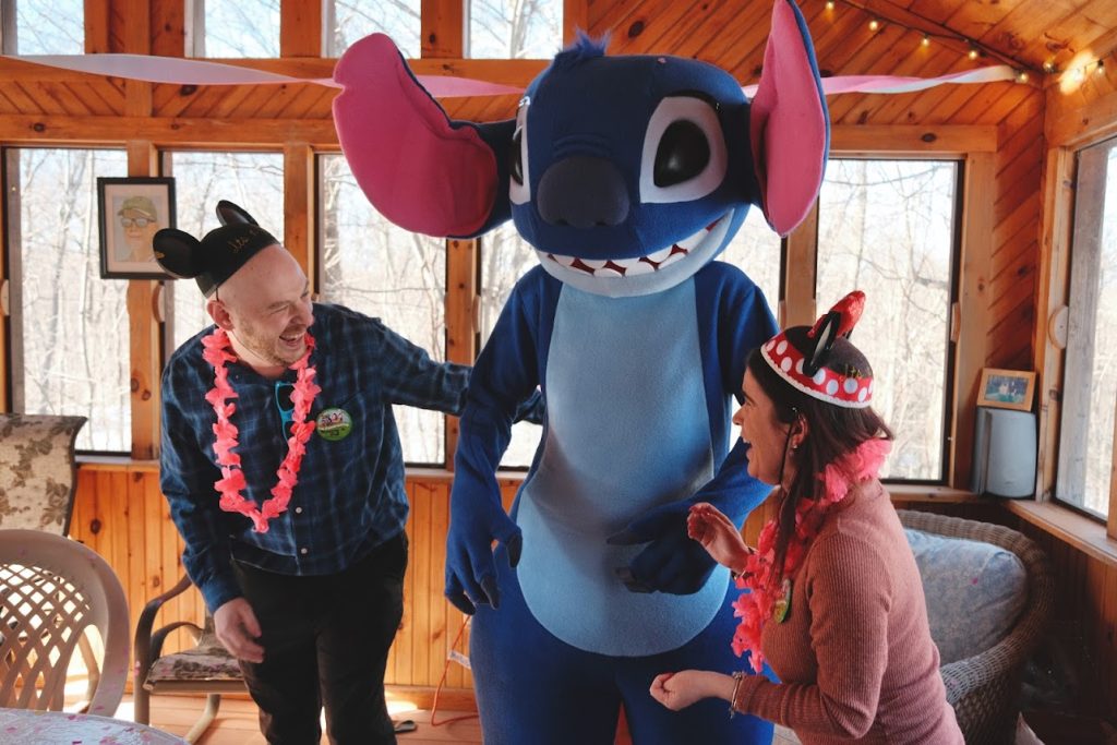 Stitch surprising people man and woman wearing Mickey Ears and leis | Rent Party Characters
