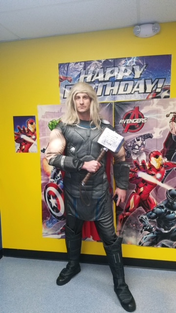 Thor holding his hammer in front of a birthday banner | Rent Party Characters